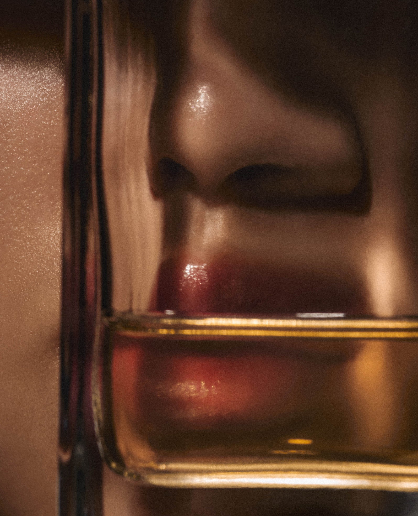 Parfumflasche  vor Lippen Nahaufnahme